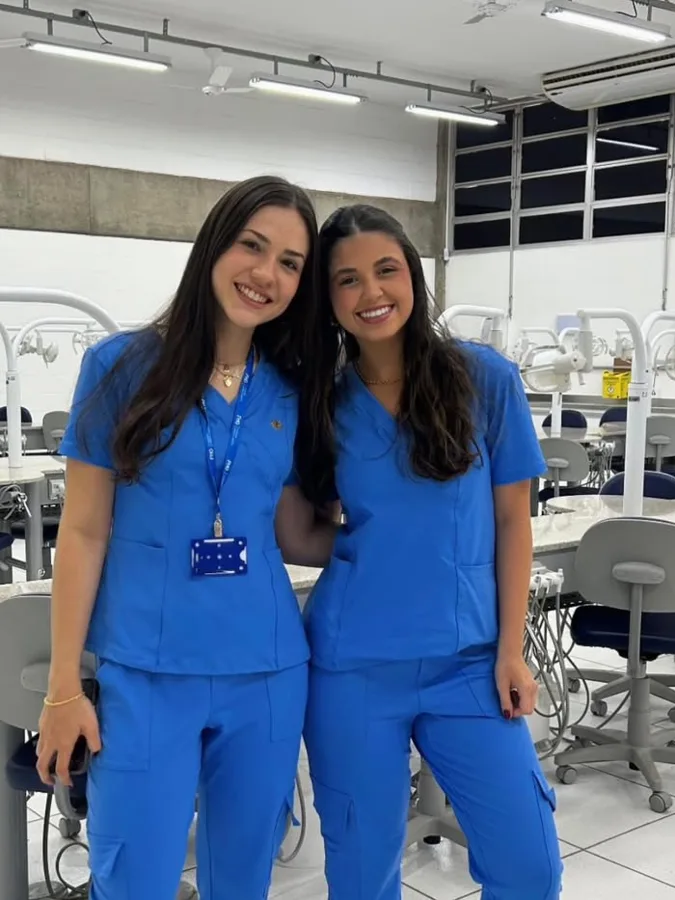 Duas estudantes combinando o scrub Kayana Stela azul